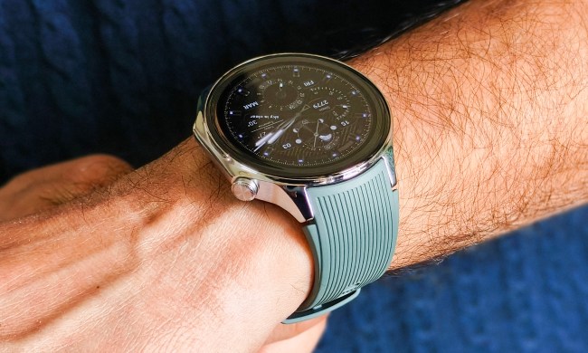 Person wearing OnePlus Watch 2 with a green strap on their left wrist.